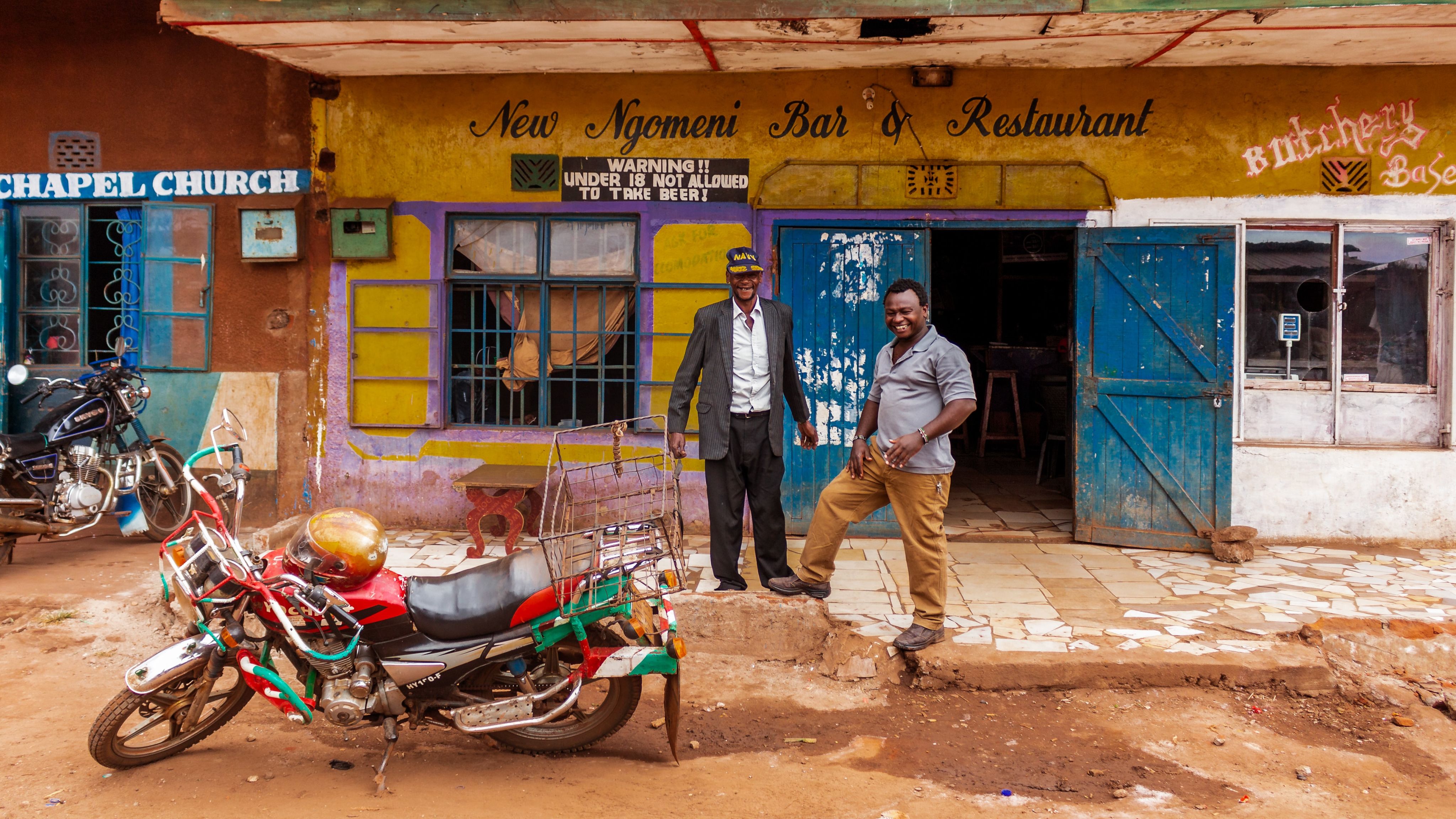 2 African men in front of a bar